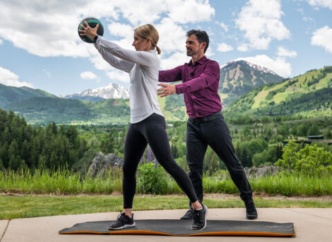 trainer helping woman use exercise ball FitForever workout app fitforever online personalized fitness programs