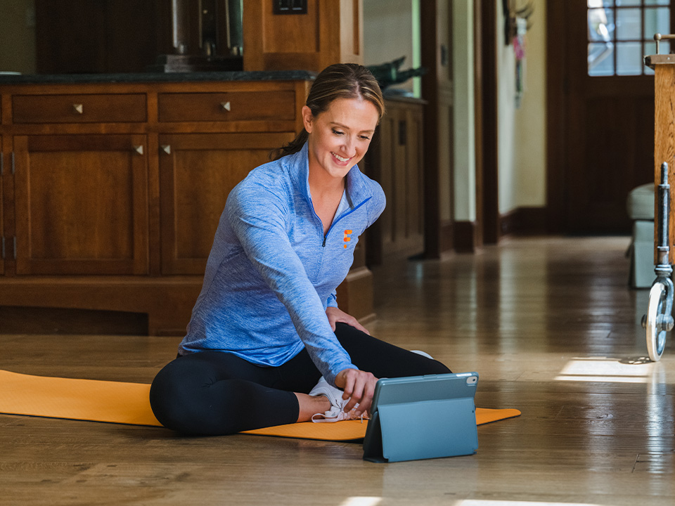 woman ready to exercise on mat and ipad in kitchen area fitforever online personalized fitness programs