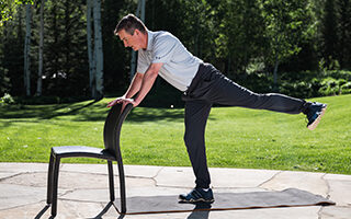 older male practices balance with a chair for support fitforever online personalized fitness programs