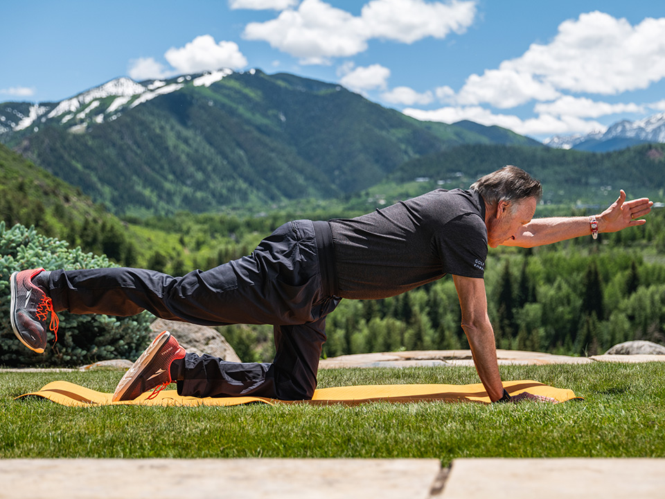 older man can balance while doing plank with one leg and one arm in air fitness programs