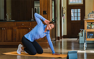 woman doing basic stretches at home fitforever online personalized fitness programs