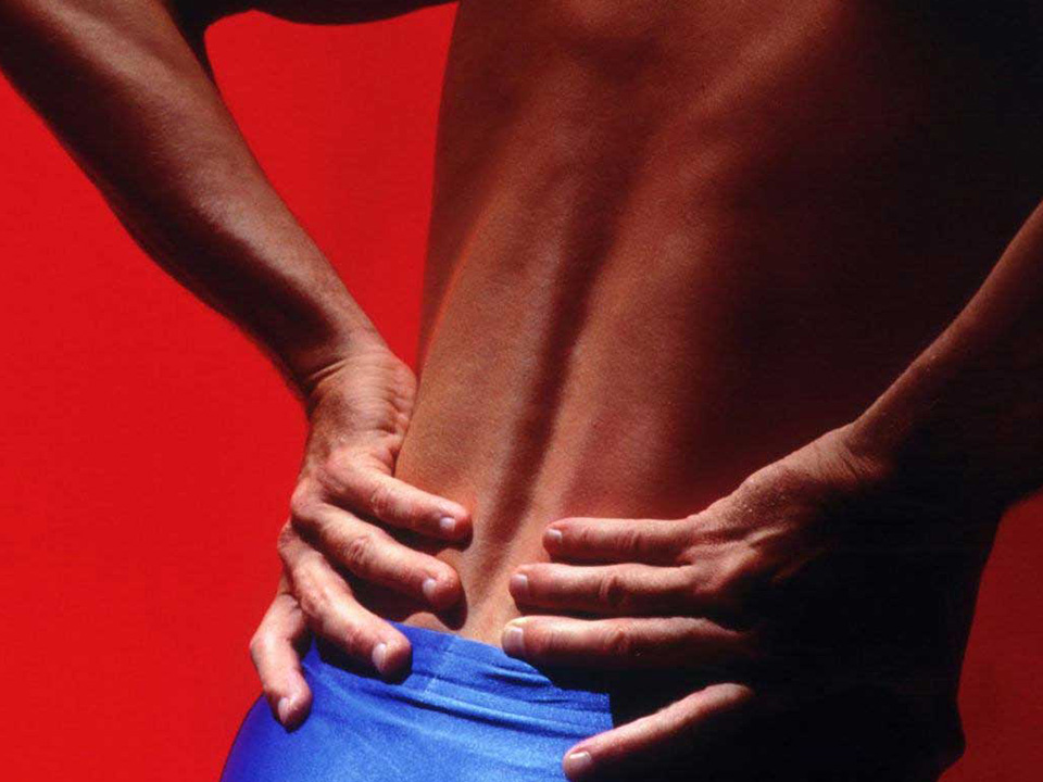 close up photo of man with lower back pain with red backdrop fitforever online personalized fitness programs