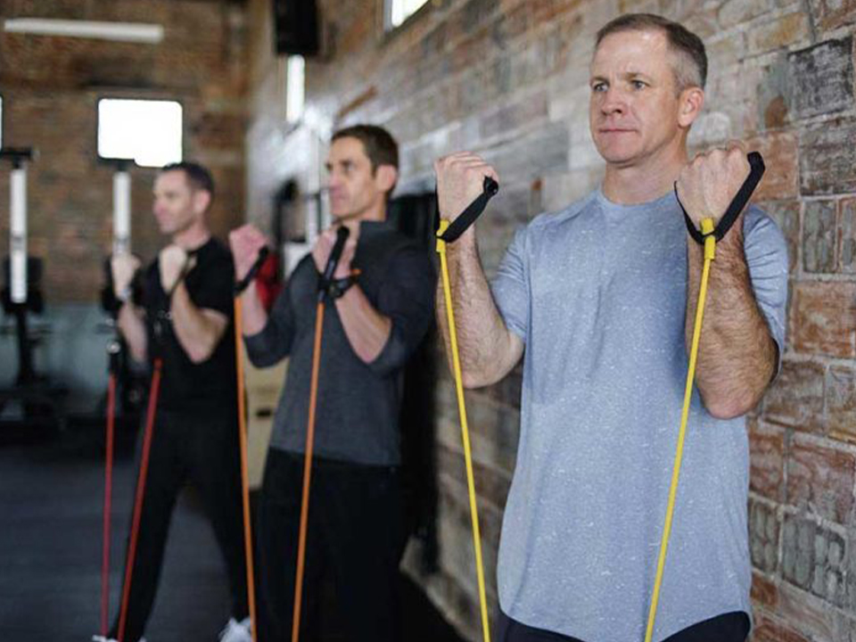 men exercising in a gym using exercise tubes fitforever online personalized fitness programs
